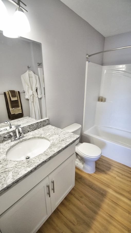 Updated bathroom with granite counter and wood flooring.