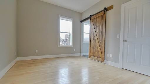 A room with a sliding barn door and a window. at Integrity Gold Coast Apartments, Cleveland, Ohio