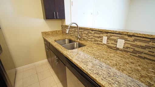 Updated apartment kitchen island with granite counters and espresso cabinets.
