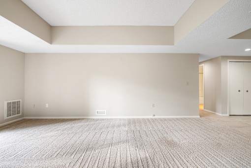 A large empty room with a carpeted floor and white walls.at Atrium in The Village, Ohio, 44122