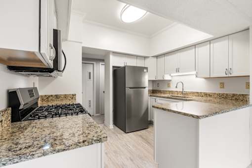 A kitchen with granite countertops and stainless steel appliances.at Atrium in The Village, Beachwood, OH 44122