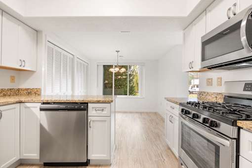 A kitchen with white cabinets and stainless steel appliances.at Atrium in The Village, Beachwood