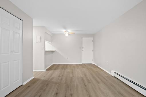 A room with wooden flooring and white walls.
