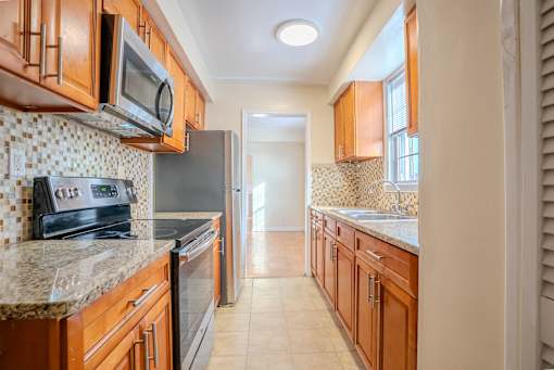 A kitchen with wooden cabinets and a tile backsplash Integrity Realty, Cleveland, OH
