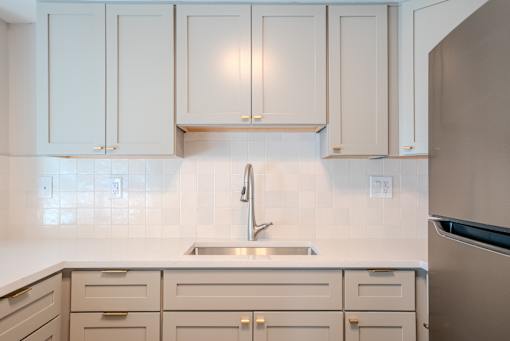 A kitchen with white cabinets and a stainless steel refrigerator t Atrium in The Village, Beachwood, OH 44122