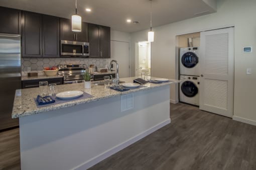 a kitchen with a counter top and a washer and dryer in a house