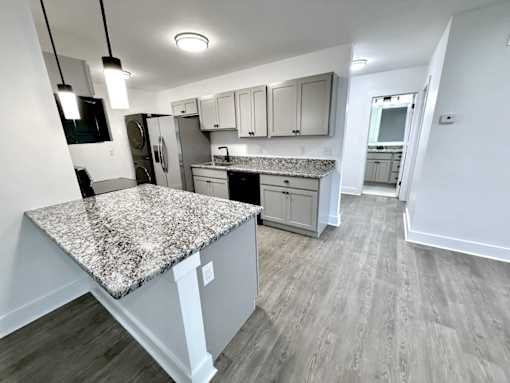 A kitchen with a granite countertop and wooden flooring Old Green Place Apartments, Beachwood, OH