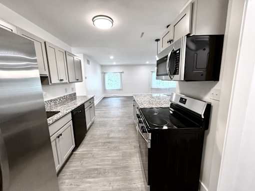 A modern kitchen with stainless steel appliances and black countertops Old Green Place Apartments, Beachwood, OH
