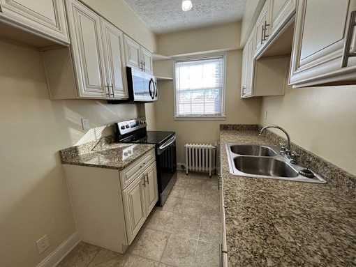 An updated galley  kitchen with granite countertops and a window Integrity Realty, Cleveland
