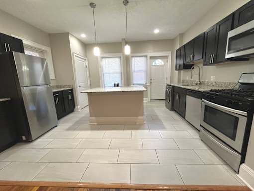 A kitchen with black appliances and white tiled floors at Integrity Cleveland Heights Apartments, Apartments, Cleveland Heights, OH