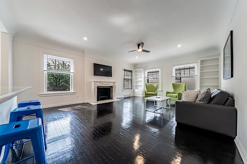 A living room with a fireplace and a grey couch.