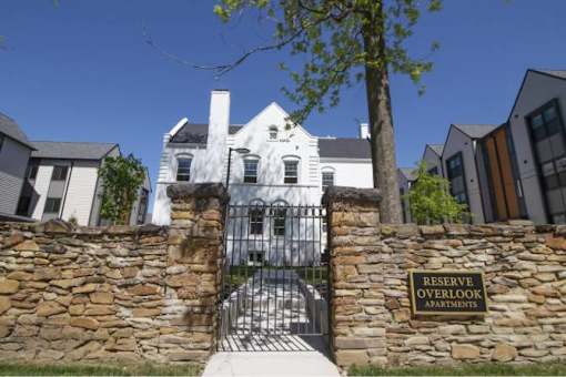 A sign that says Reserve Overlook Apartments stands in front of a gate.