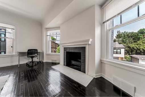 A black and white room with a fireplace and a chair.