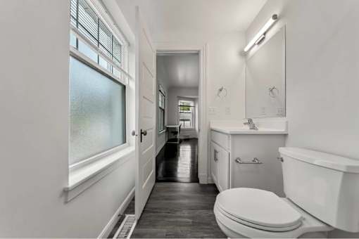 A white bathroom with a toilet, sink, and bathtub.