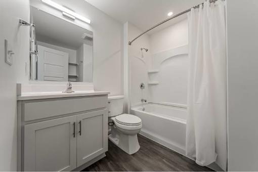 A white bathroom with a toilet, sink, and bathtub.