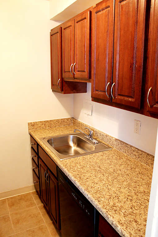 A kitchen with a granite counter top and wooden cabinets Integrity Realty, Cleveland, OH