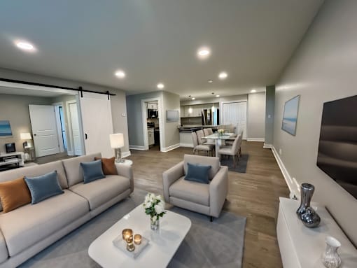Virtually staged living room with plank style flooring at Old Green Place Apartments, Integrity Realty LLC, Beachwood, OH
