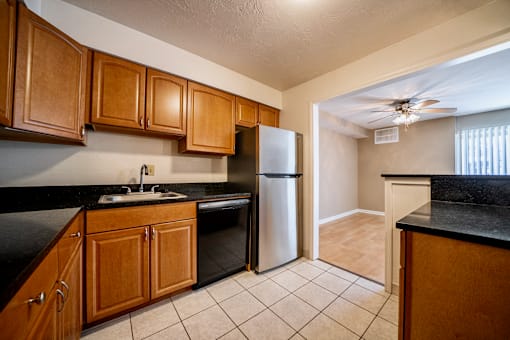 A kitchen with wooden cabinets and a black counter top at Westwood Meadows, Westlake, OH, 44145