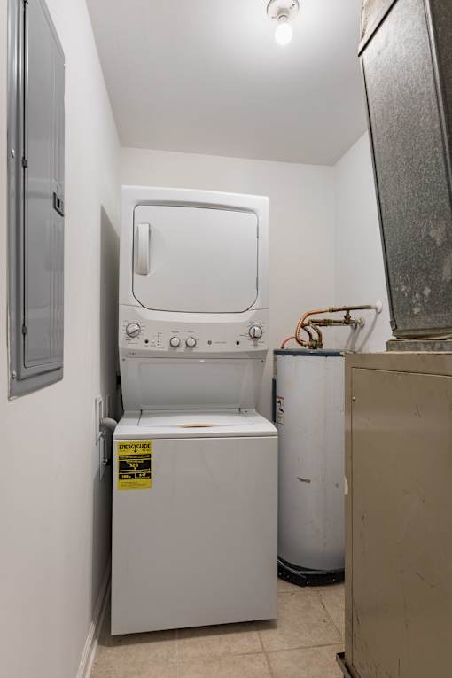 A small white washing machine is in a laundry room.