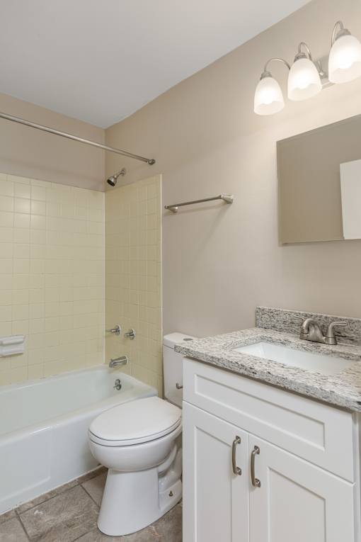 A white toilet sits in a bathroom next to a sink.