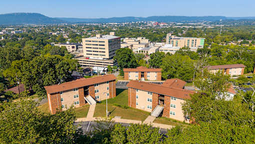 A large building complex with a parking lot in front.