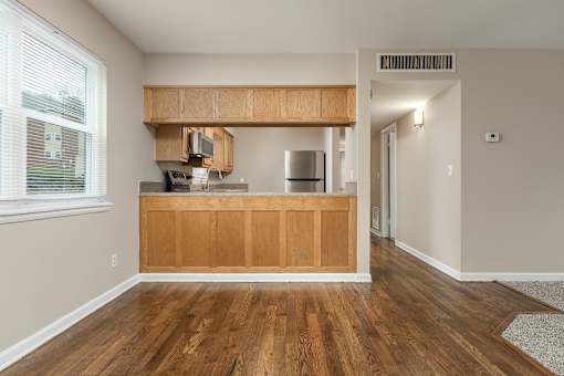 A kitchen with wooden cabinets and a stainless steel refrigerator.