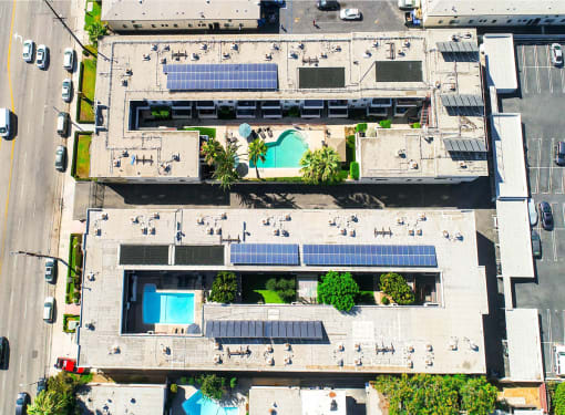 Aerial drone image of Sherman Oaks Gardens, showing solar panels and energy-efficient white roof.