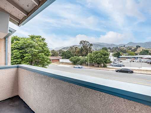 Private balcony with view of tree-lined surrounding community.