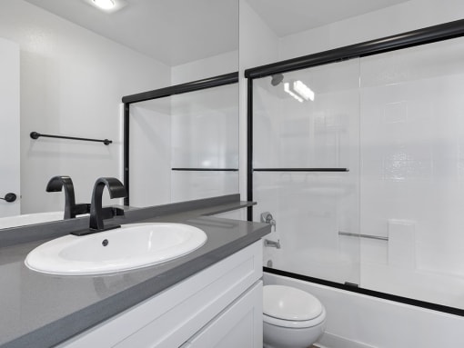 White bathroom with modern fixtures, shower, and tub.