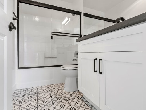 White bathroom with shower, tub, and tiled floor.