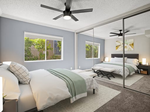 Carpeted bedroom with ceiling fan and large mirrored closets.