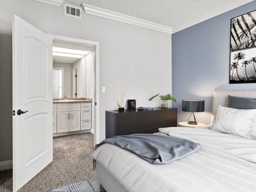 Carpeted bedroom with private bathroom.