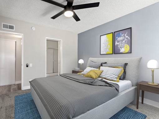 Carpeted bedroom with ceiling fan and private bathroom.