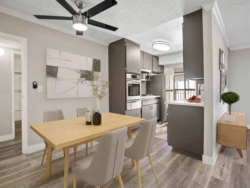 Hardwood floored dining room with view of modern-styled kitchen.