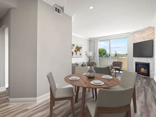 Hardwood floored dining room with view of balcony and stone walled fireplace.