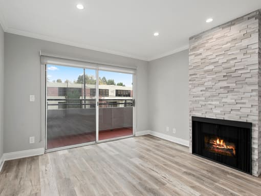 Cozy stone-walled fireplace in the living room with view of balcony.