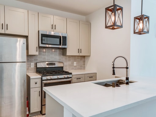 Kitchen with new modern styled faucet, stainless steel appliances, and refrigerator.