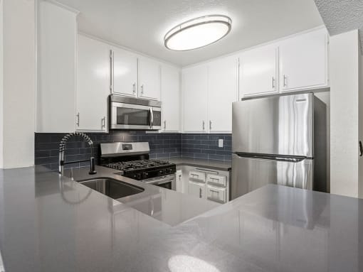 Kitchen with stainless steel oven, microwave, and fridge.