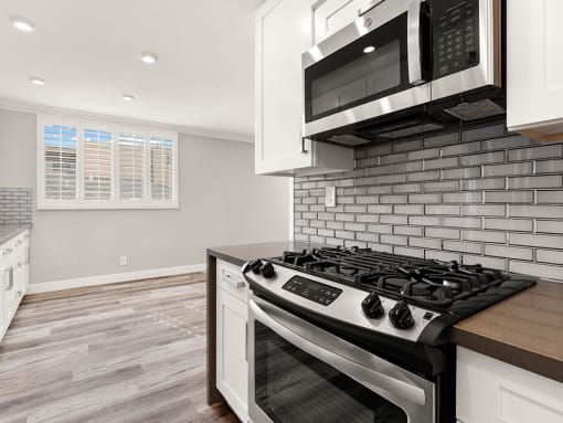 Wrap around kitchen with stainless steel microwave and oven.