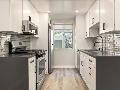 Kitchen with stainless steel fridge, oven, and microwave.