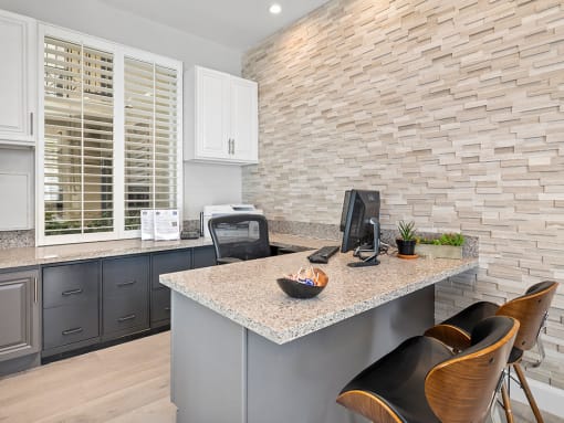 Stylish modern leasing office with same stone accent wall found in apartments
