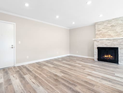 Hardwood floored living room with stone accented fireplace.