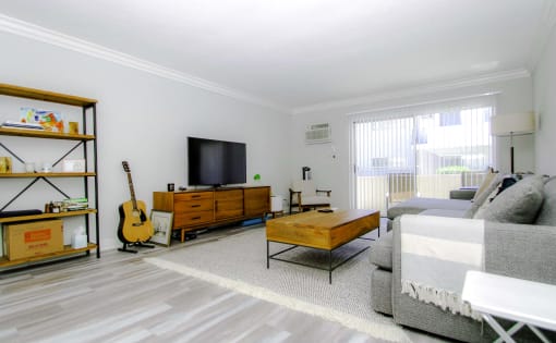 Living room with hardwood floor and large patio windows.