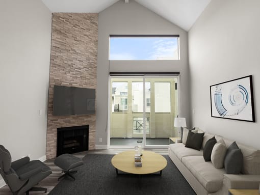 Hardwood floored living room with view of stone accent wall, fireplace, and high third-floor ceilings.