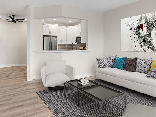 Hardwood floored living room with view of kitchen and dining area.