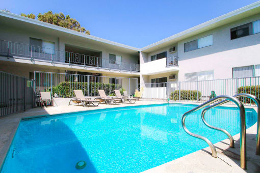 Beautiful gated pool with lounging area.