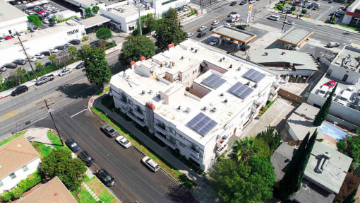 Aerial drone photo of Magnolia Terrace showing solar panels and energy-efficient white roof.