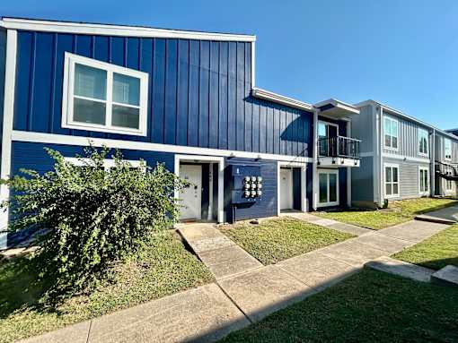 A blue building with a white window and a white door.