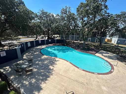 A round above ground pool with a table and chairs around it.
