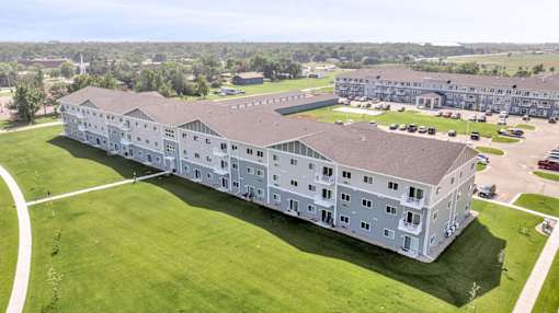 A large white building with a green lawn in front.